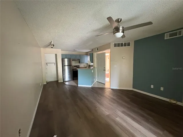 a view of empty room with wooden floor and ceiling fan