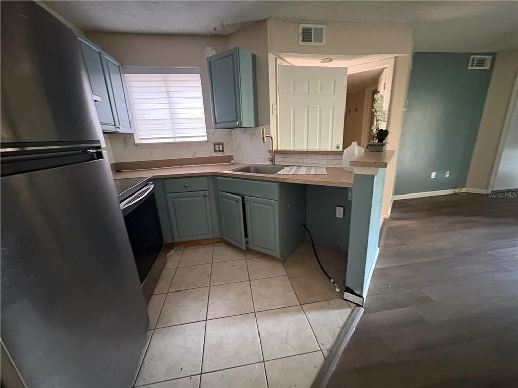 1940 Lake Atriums Circle, Unit 101 Orlando, FL 32839 - Photo 4 of 14 a kitchen with a sink a refrigerator and window