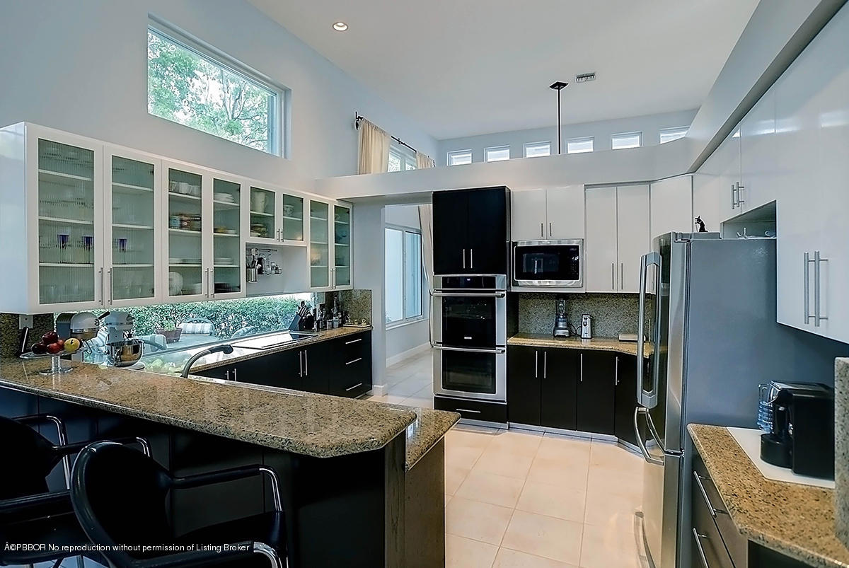 2570 Hampton Bridge Road Delray Beach, FL 33445 - Photo 14 of 40 a kitchen with stainless steel appliances granite countertop a stove refrigerator and a sink