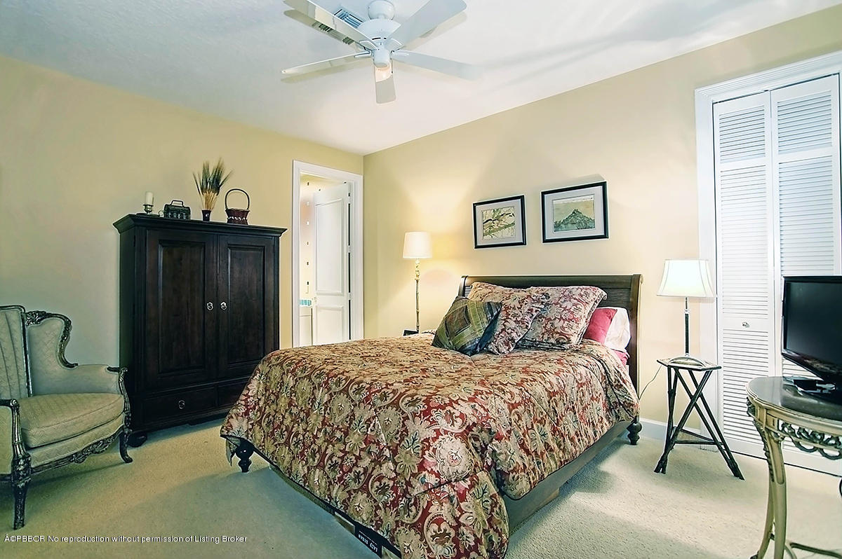 2570 Hampton Bridge Road Delray Beach, FL 33445 - Photo 24 of 40 a bedroom with a bed and a chandelier