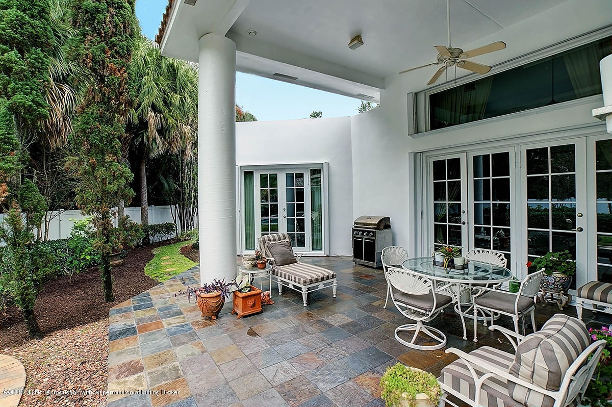 2570 Hampton Bridge Road Delray Beach, FL 33445 - Photo 35 of 40 a view of a patio with table and chairs potted plants and floor to ceiling window