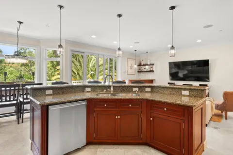 a dining room with furniture large windows a chandelier and a rug