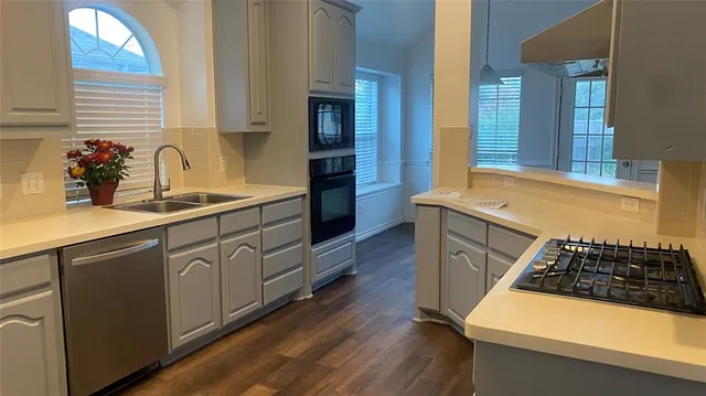 a kitchen with stainless steel appliances granite countertop a sink stove and cabinets
