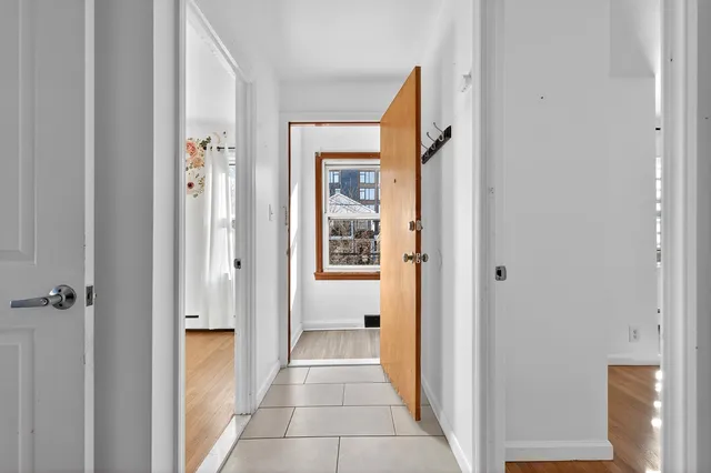 a view of a hallway with a cabinet and a door