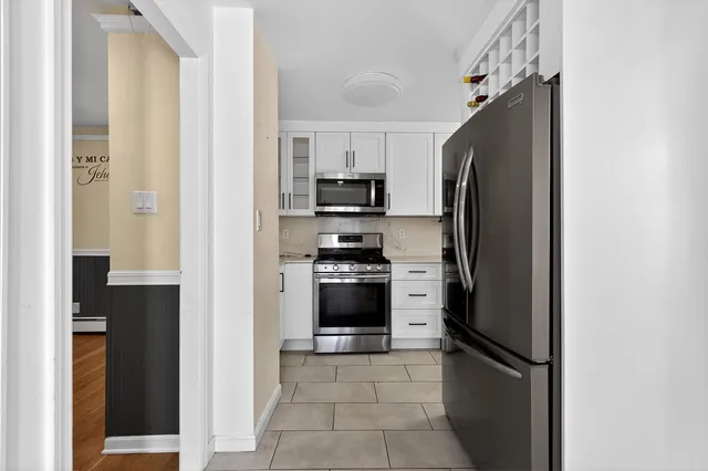 a kitchen with stainless steel appliances and refrigerator