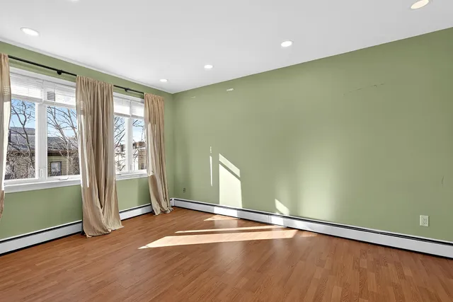 a view of a room with wooden floor and windows