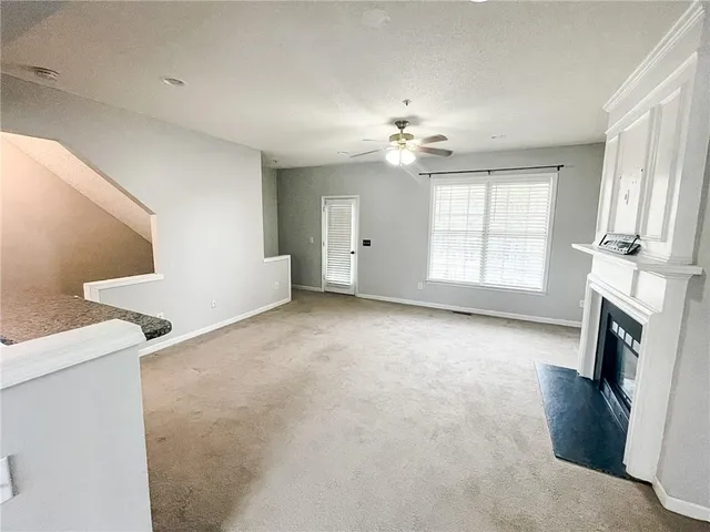 a view of an empty room with a fireplace and a window