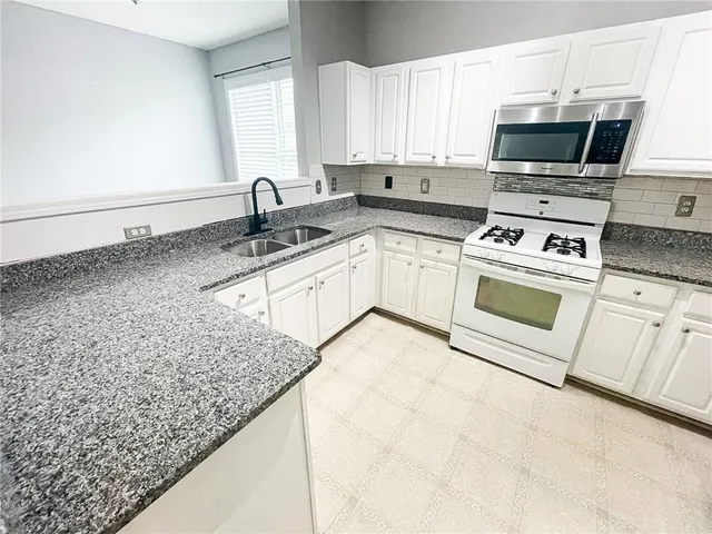 a kitchen with appliances a sink and a counter top space