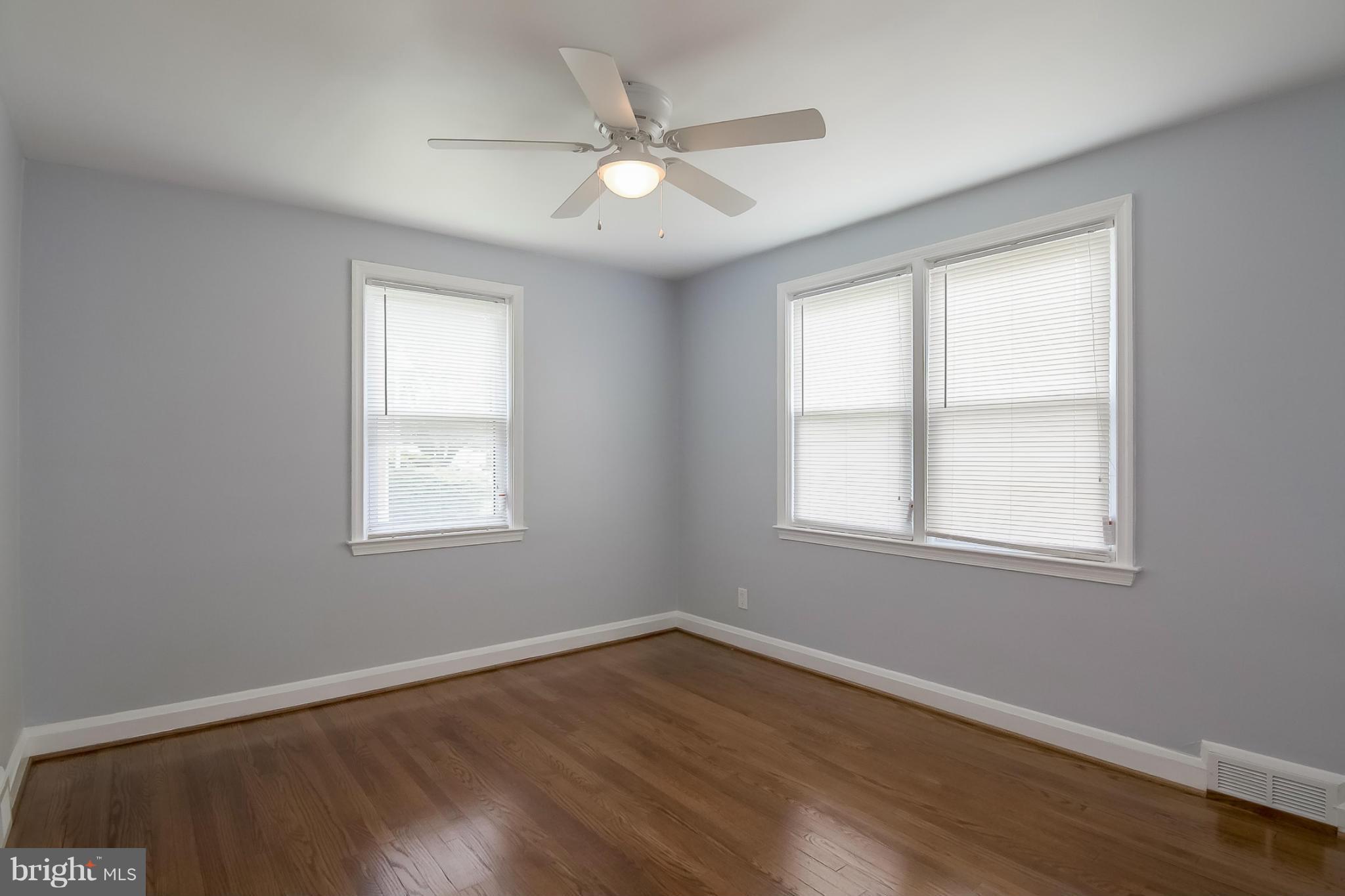 3495 Hillsmere Road Baltimore, MD 21207 - Photo 13 of 19 an empty room with wooden floor and windows