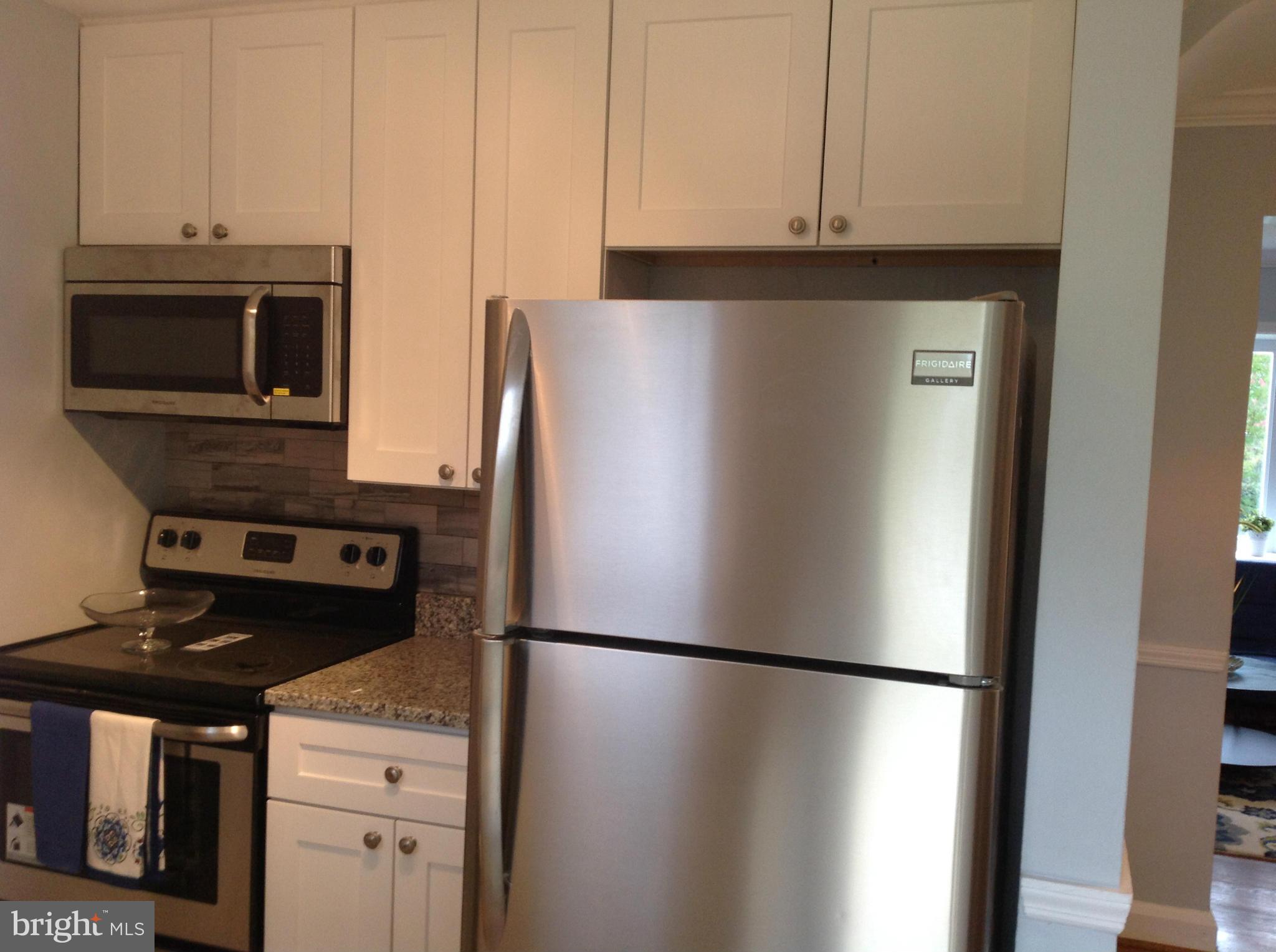 3495 Hillsmere Road Baltimore, MD 21207 - Photo 9 of 19 a white refrigerator freezer and a stove sitting inside of a kitchen