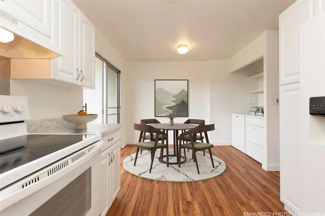 a kitchen with a dining table chairs and white cabinets