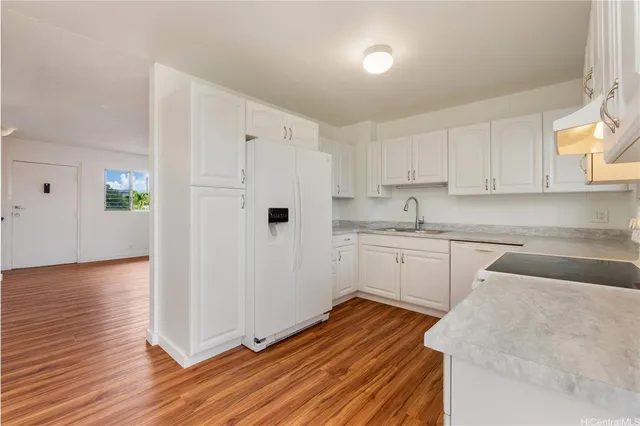 a kitchen with wooden floors and white appliances