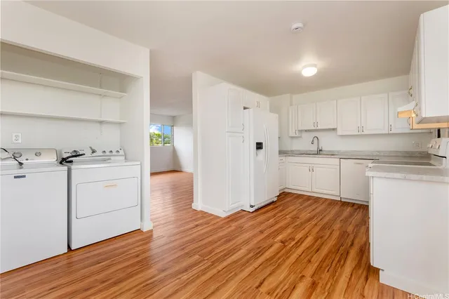 a kitchen with white cabinets and white appliances