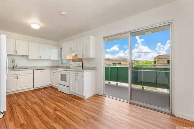 a kitchen with a sink cabinets and wooden floor