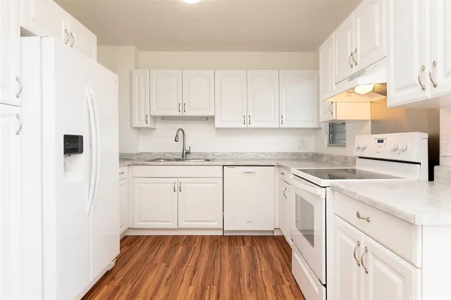 a kitchen with white cabinets and white appliances