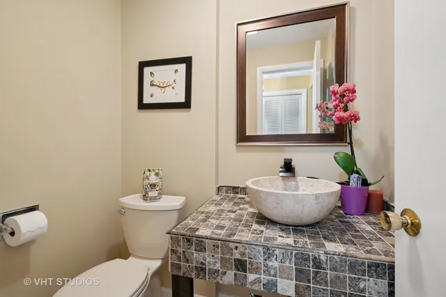 a bathroom with a granite countertop toilet a sink and mirror