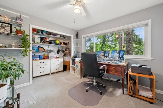 a view of a workspace with furniture and a window