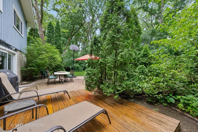 a view of backyard with seating space and trees in the background