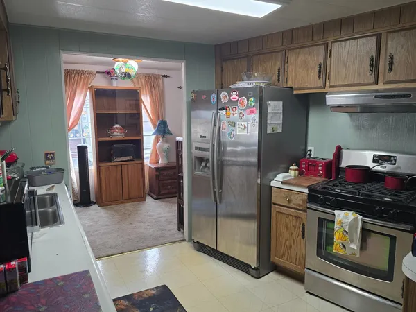 a kitchen with stainless steel appliances granite countertop a refrigerator and a stove