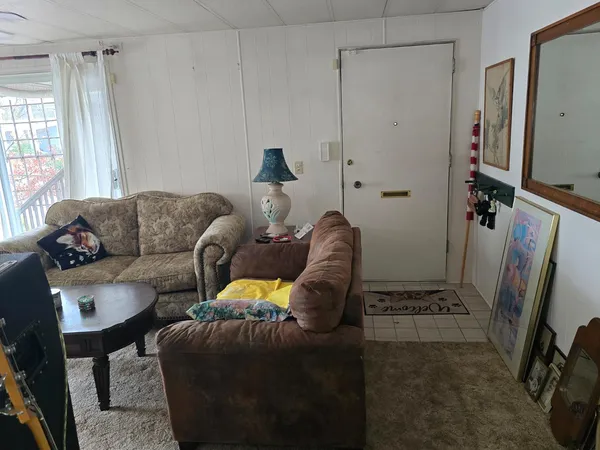 a living room with furniture a window and a flat screen tv