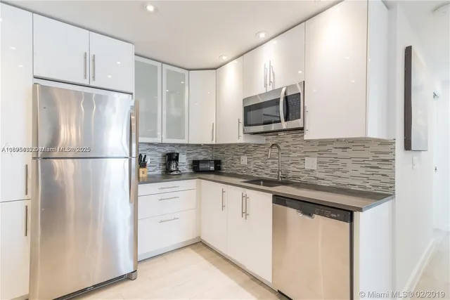 a kitchen with stainless steel appliances granite countertop a refrigerator sink and microwave