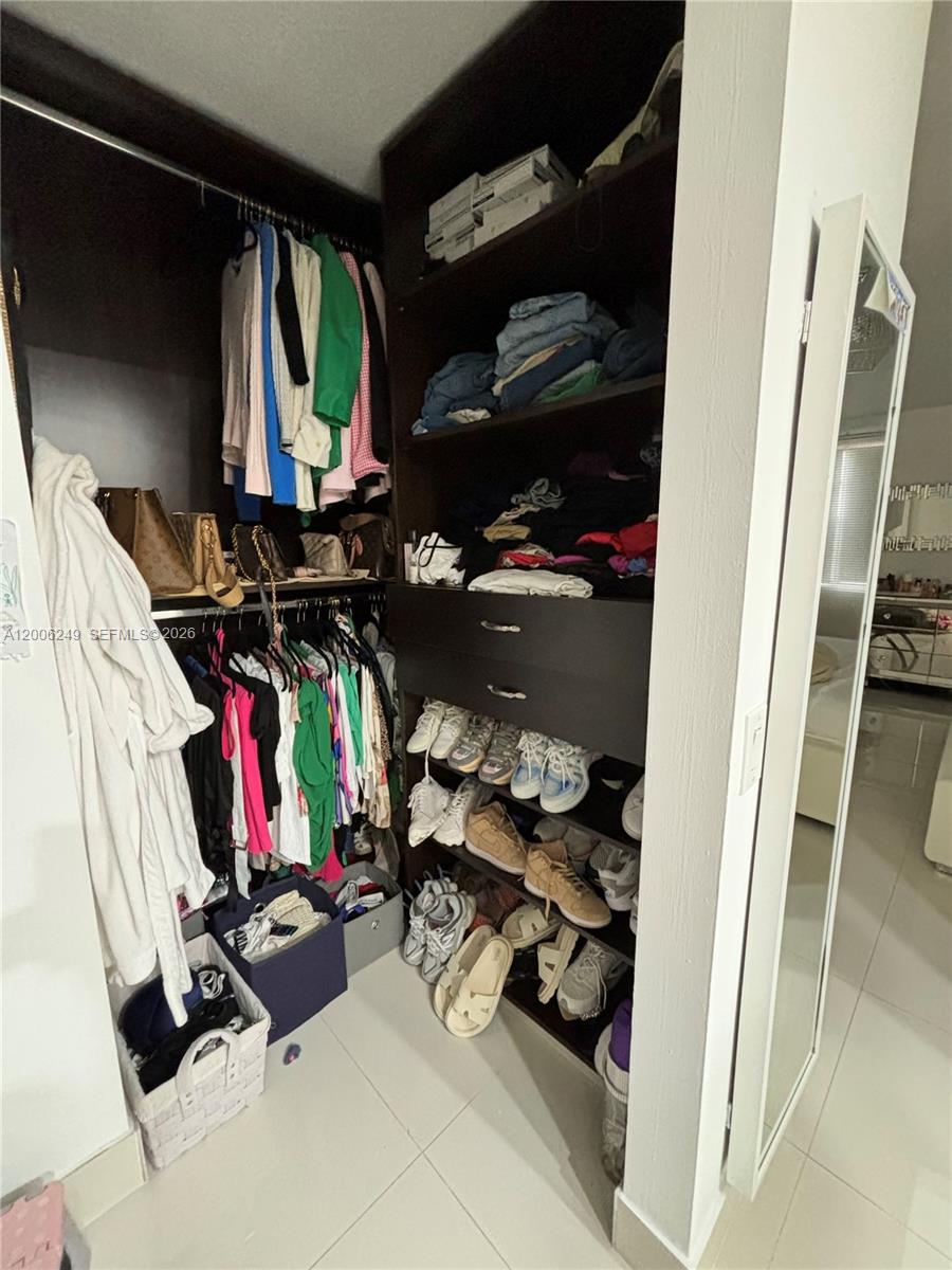 1351 Garden Road Weston, FL 33326 - Photo 11 of 20 a view of walk in closet with clothes and shoes