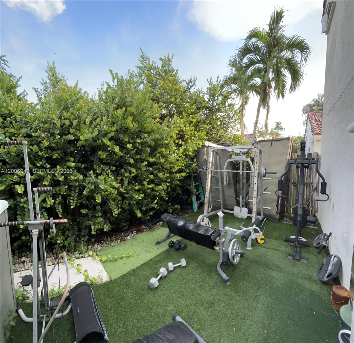 1351 Garden Road Weston, FL 33326 - Photo 19 of 20 a view of a patio with table and chairs potted plants and palm tree