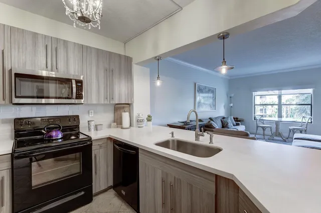 a kitchen with stainless steel appliances granite countertop a refrigerator a stove a sink and a microwave