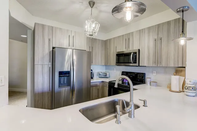a kitchen with a sink a stove and chairs