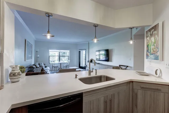 a kitchen with stainless steel appliances granite countertop a sink a stove a refrigerator a microwave oven with white cabinets and wooden floor