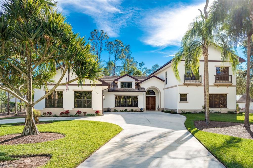 6010 Bur Oaks Lane Naples, FL 34119 - Photo 1 of 23 a front view of a house with a yard