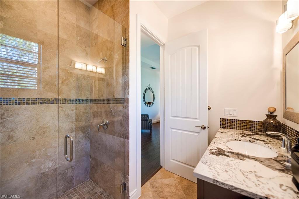 6010 Bur Oaks Lane Naples, FL 34119 - Photo 14 of 23 a bathroom with a granite countertop sink and shower