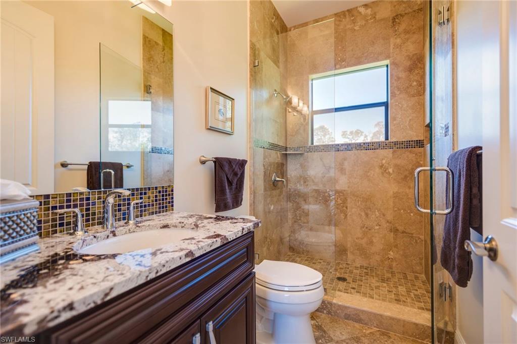 6010 Bur Oaks Lane Naples, FL 34119 - Photo 20 of 23 a bathroom with a granite countertop sink toilet and shower