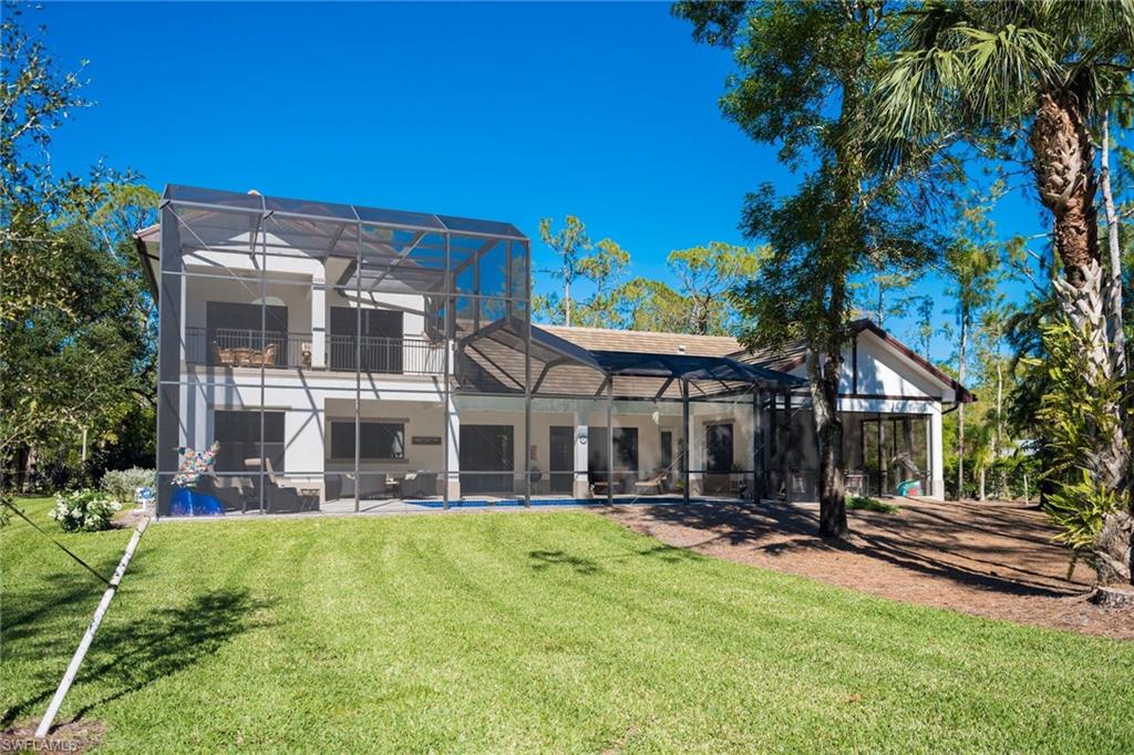 6010 Bur Oaks Lane Naples, FL 34119 - Photo 2 of 23 a view of a house with a yard patio and fire pit