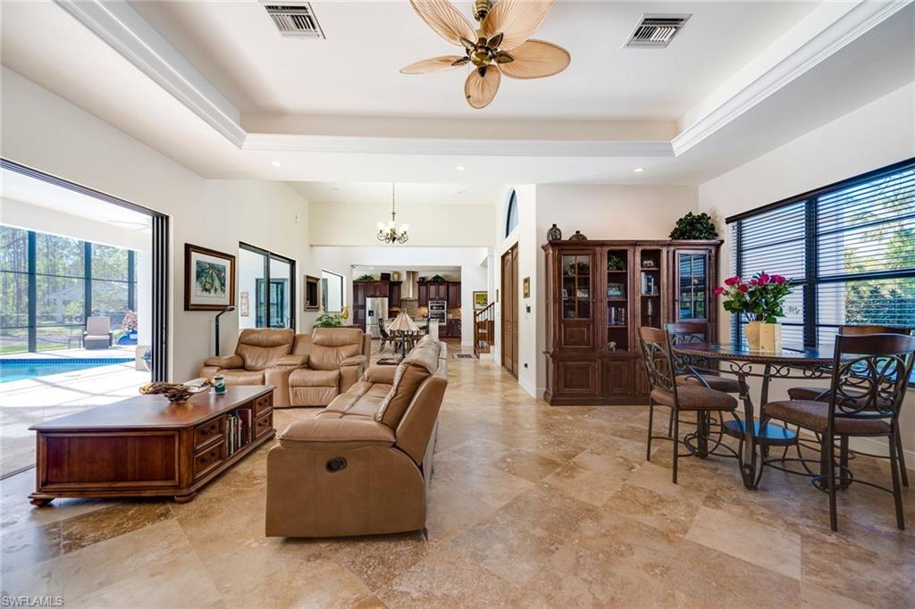 6010 Bur Oaks Lane Naples, FL 34119 - Photo 5 of 23 a living room with lots of furniture and a book shelf