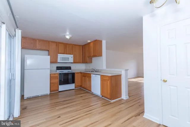 a kitchen with granite countertop a refrigerator and a sink