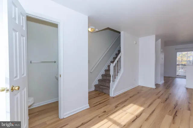 a view of a hallway with wooden floor and staircase