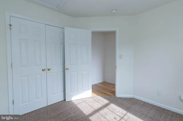 a view of a room with wooden floor and a bathroom
