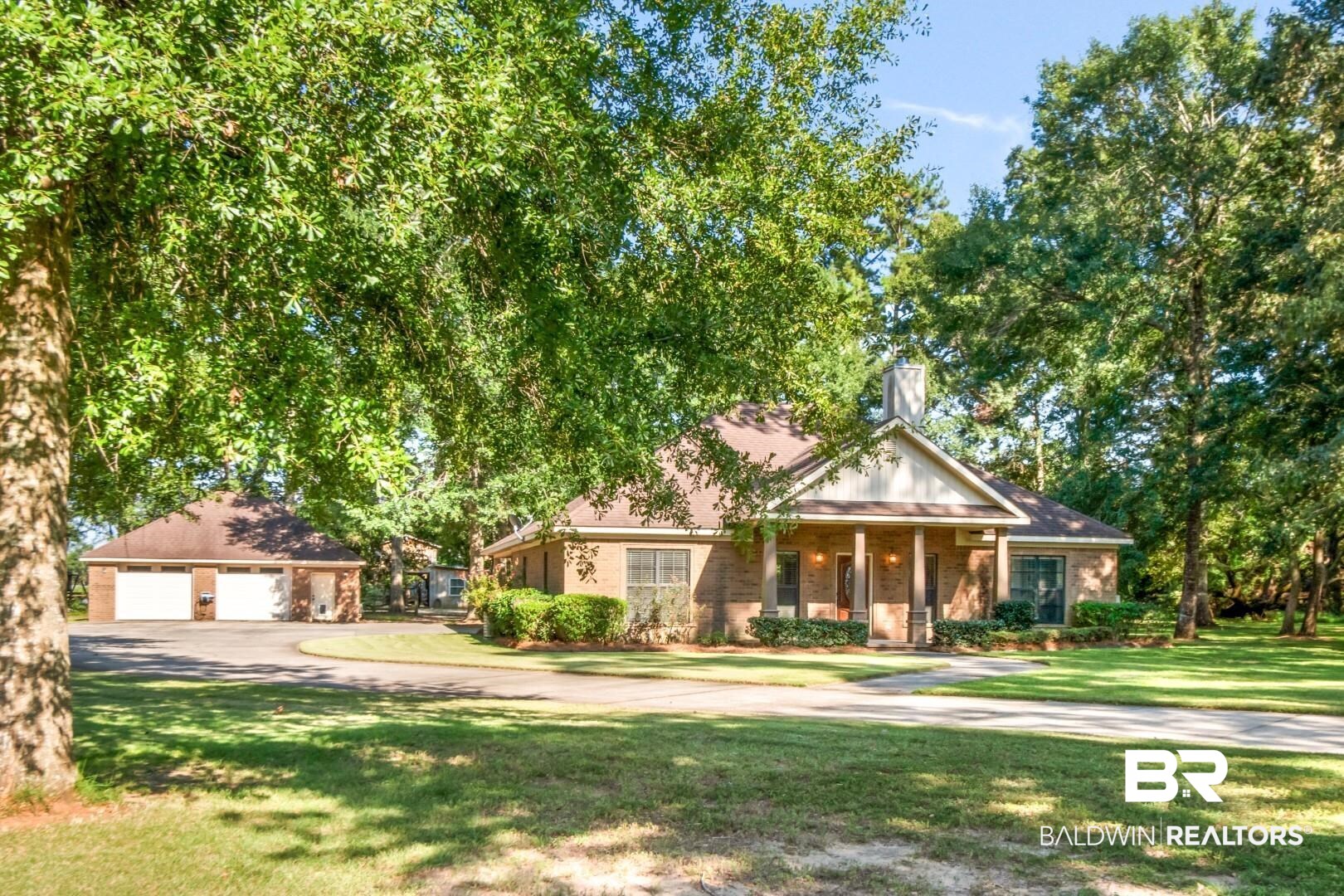 1360 Dykes Road North Mobile, AL 36608 - Photo 1 of 40 View of front facade with covered porch, a front lawn, an outbuilding, and a detached garage