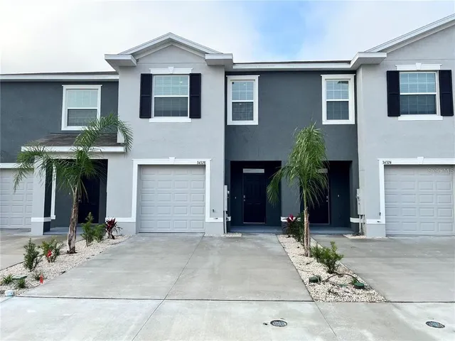 a front view of a house with a yard and garage