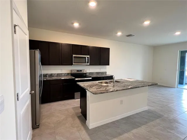 a kitchen with a sink stove and refrigerator