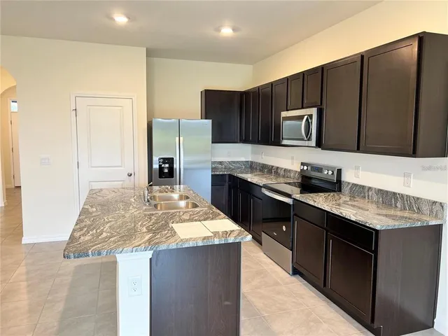 a kitchen with stainless steel appliances granite countertop a stove top oven a sink and dishwasher