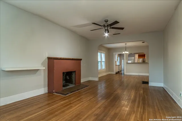 a view of empty room with wooden floor and fireplace