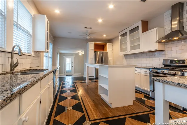 a large kitchen with stainless steel appliances granite countertop a stove and a sink