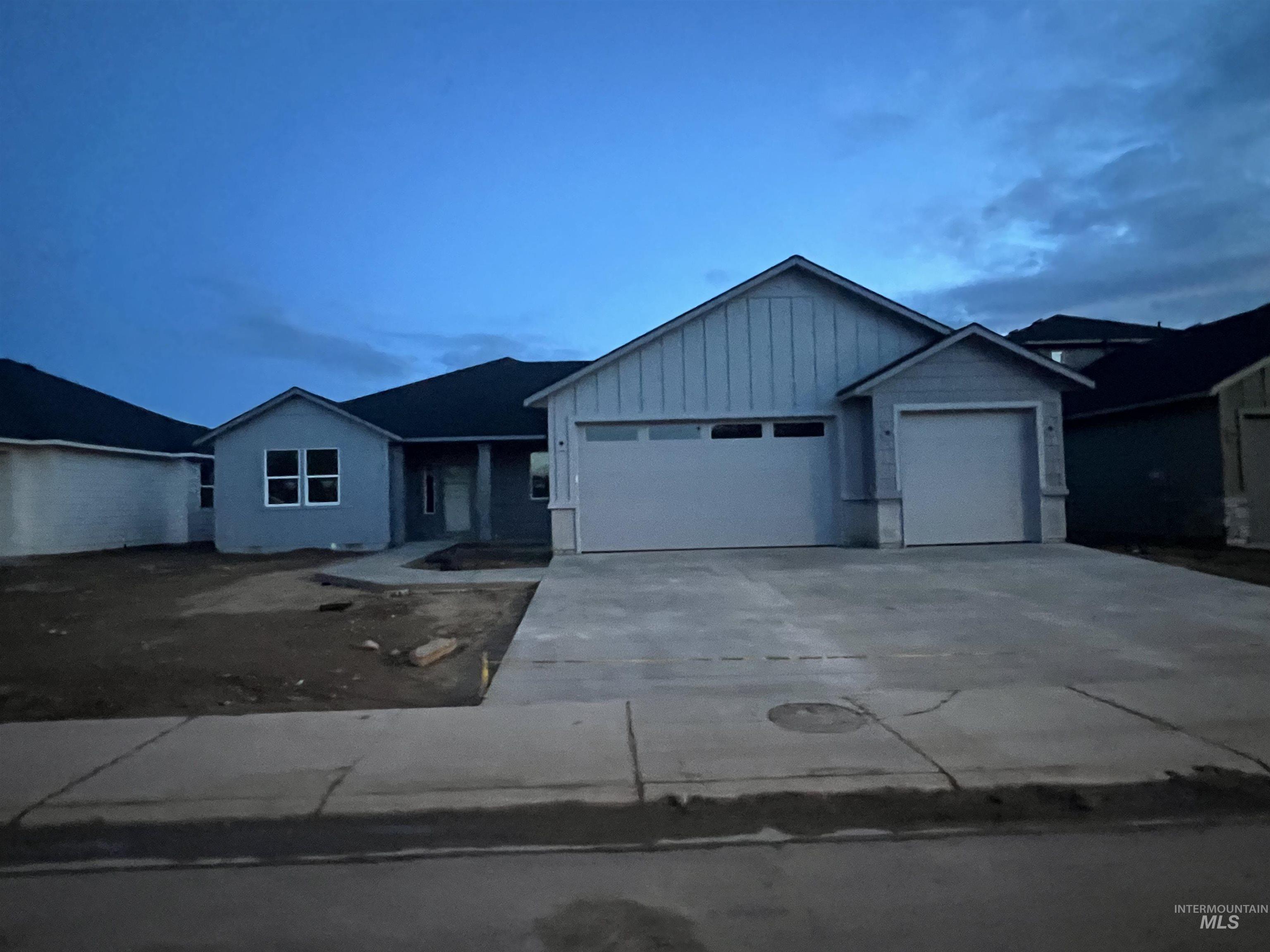 Single story home with a garage, concrete driveway, and board and batten siding