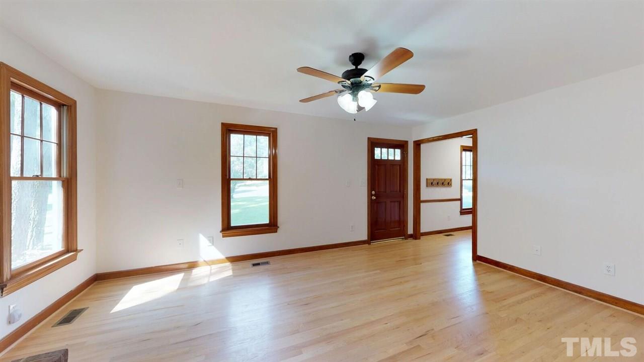 5913 Stable Court Raleigh, NC 27612 - Photo 2 of 25 a view of an empty room with window and wooden floor