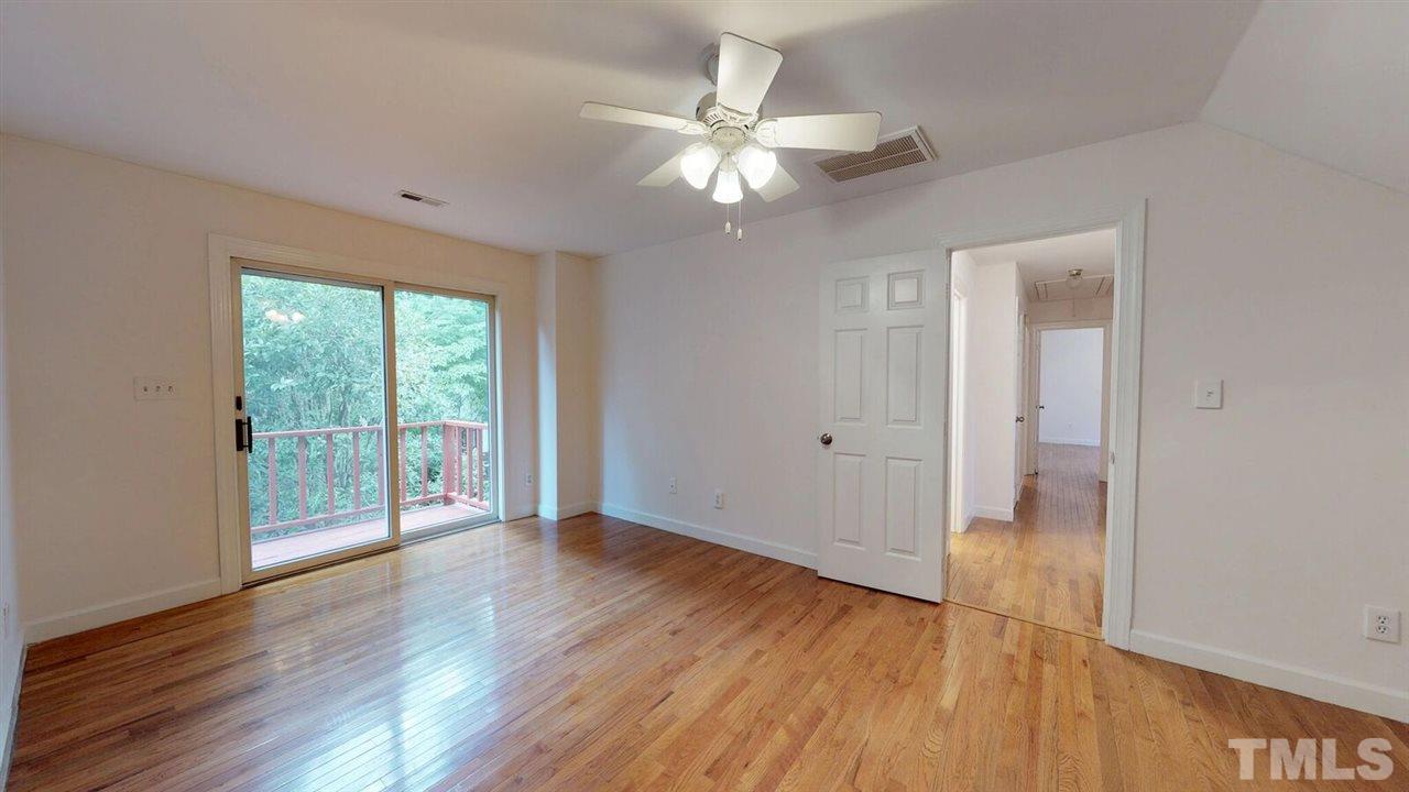 5913 Stable Court Raleigh, NC 27612 - Photo 15 of 25 a view of an empty room with wooden floor and a window