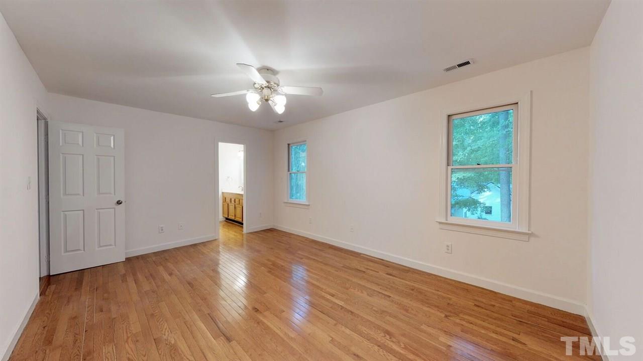 5913 Stable Court Raleigh, NC 27612 - Photo 19 of 25 a view of an empty room with wooden floor and a window
