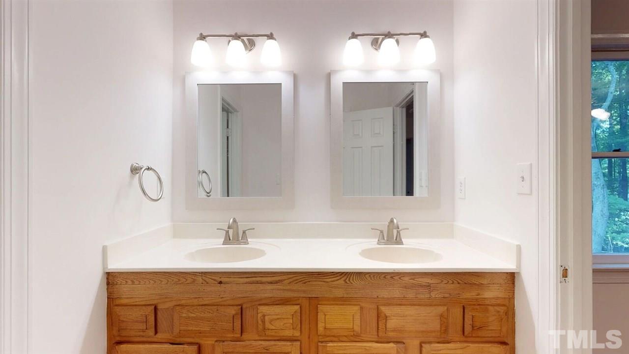 5913 Stable Court Raleigh, NC 27612 - Photo 20 of 25 a bathroom with double vanity sinks and a mirror