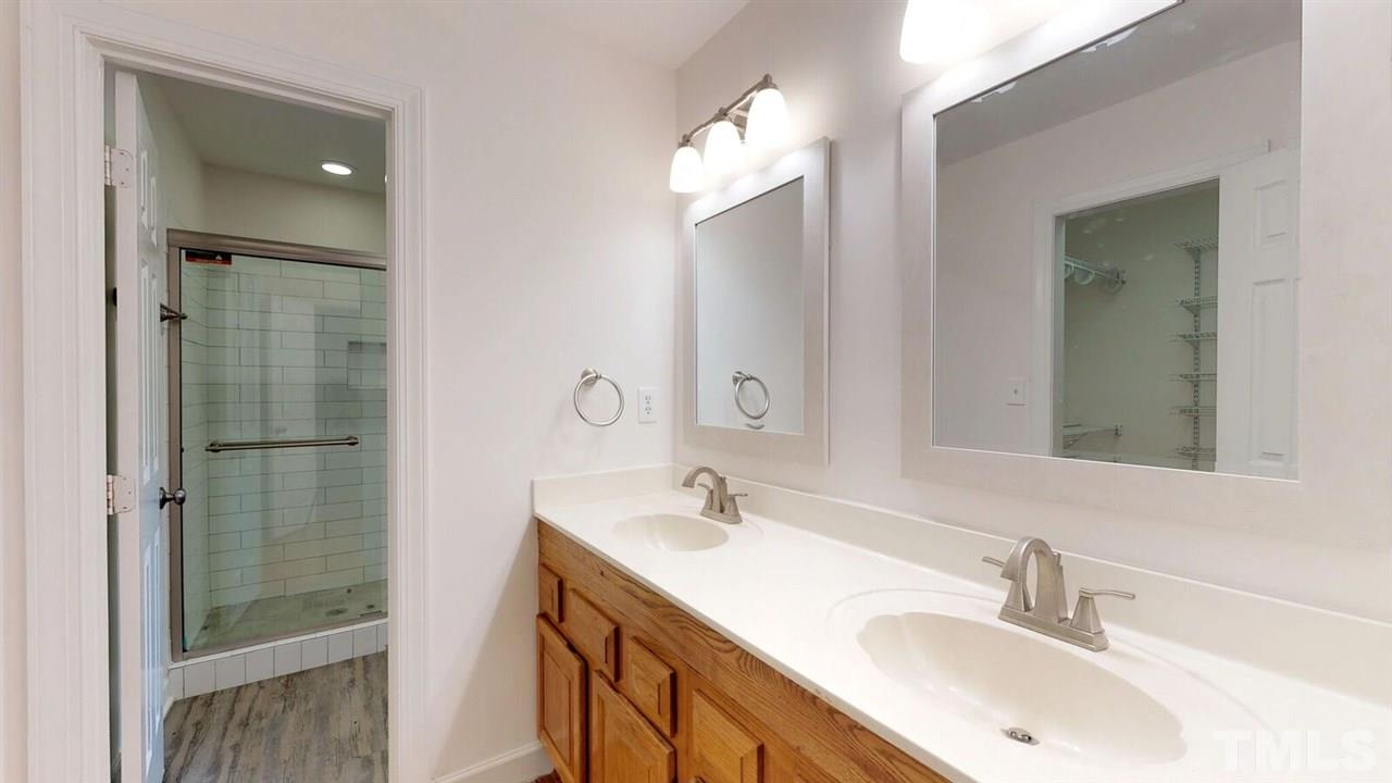 5913 Stable Court Raleigh, NC 27612 - Photo 21 of 25 a bathroom with a double vanity sink and a mirror